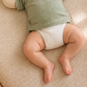 Baby's legs and diaper area remain open below the Bolero Swaddle